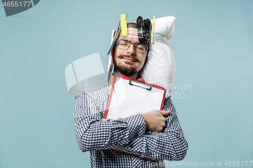 Image of Tired man sleeping at home having too much work. Bored businessman with pillow