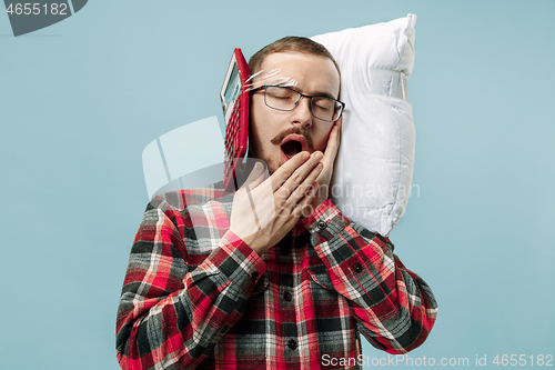 Image of Tired man sleeping at home having too much work. Bored businessman with pillow