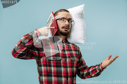 Image of Tired man sleeping at home having too much work. Bored businessman with pillow