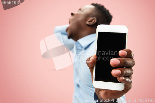 Image of Beautiful man looking suprised and bewildered isolated on pink