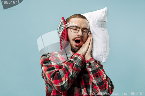 Image of Tired man sleeping at home having too much work. Bored businessman with pillow