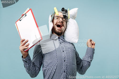 Image of Tired man sleeping at home having too much work. Bored businessman with pillow