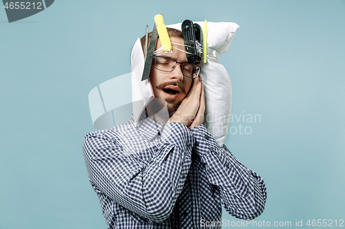 Image of Tired man sleeping at home having too much work. Bored businessman with pillow