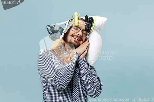 Image of Tired man sleeping at home having too much work. Bored businessman with pillow