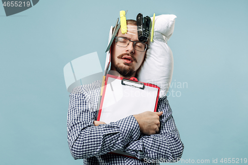 Image of Tired man sleeping at home having too much work. Bored businessman with pillow