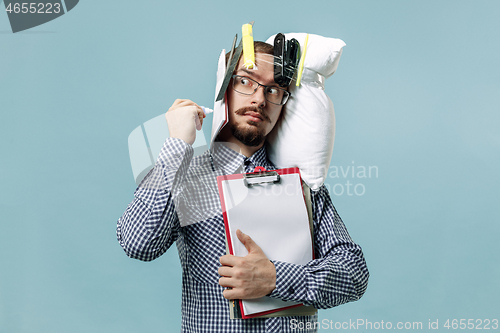 Image of Tired man sleeping at home having too much work. Bored businessman with pillow