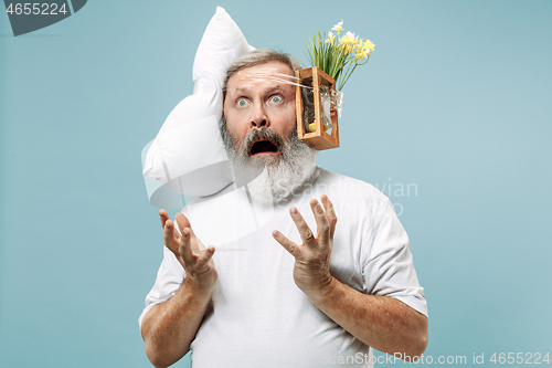 Image of Tired man sleeping at home having too much work. Bored businessman with pillow and hourglass