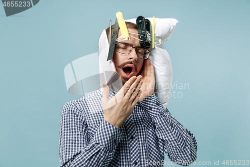 Image of Tired man sleeping at home having too much work. Bored businessman with pillow