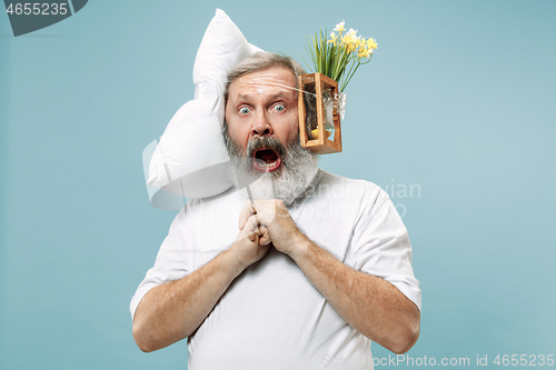 Image of Tired man sleeping at home having too much work. Bored businessman with pillow and hourglass