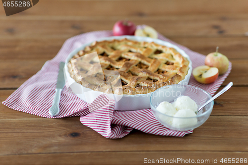 Image of apple pie with ice cream on wooden table