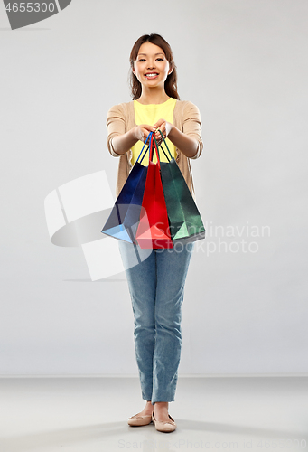 Image of happy asian woman with shopping bags