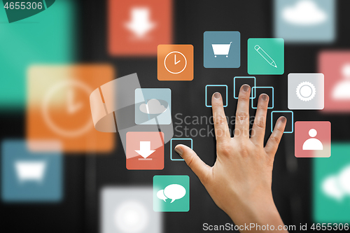 Image of hand using interactive panel with app icons on it