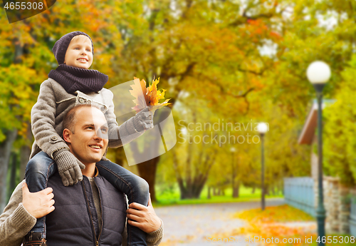 Image of happy family having fun in autumn park