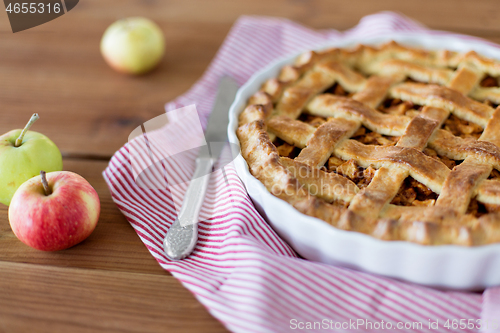 Image of close up of apple pie in baking mold and knife