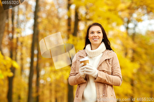 Image of woman drinking takeaway coffee in autumn park