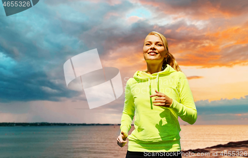 Image of woman running over sea background