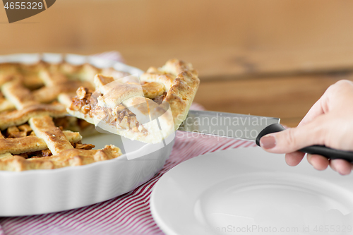 Image of close up of hand with piece of apple pie on knife