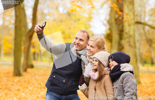 Image of happy family with camera in autumn park