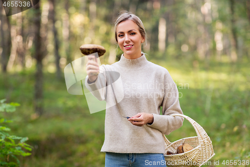 Image of young woman with mushroom in autumn forest