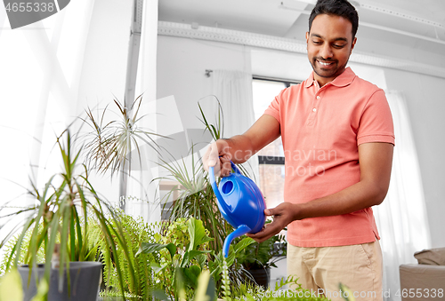 Image of indian man watering houseplants at home