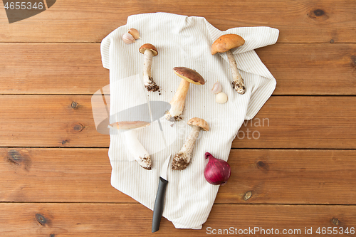 Image of edible mushrooms, kitchen knife and towel