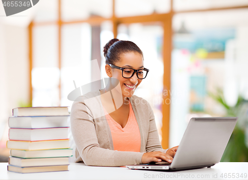 Image of female student with laptop computer and books