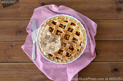 Image of close up of apple pie in baking mold and knife