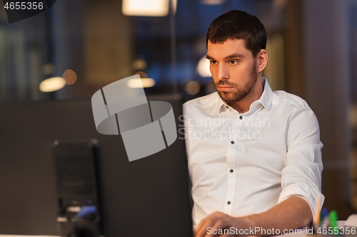 Image of businessman with computer working at night office