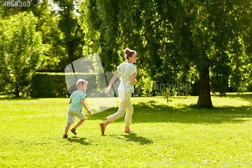 Image of mother and son playing catch game at summer park