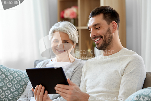 Image of old mother and adult son with tablet pc at home