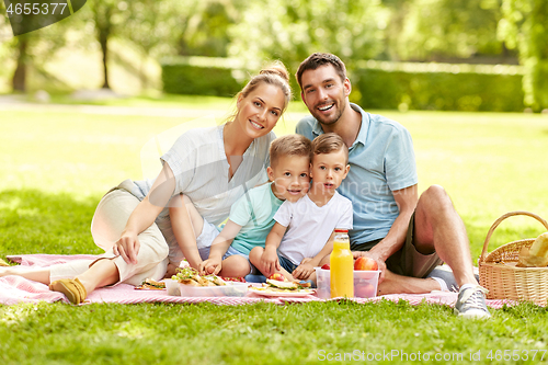 Image of portrait of family having picnic at summer park