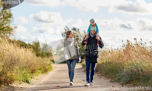 Image of happy family walking along autumn road