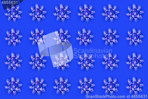 Image of Lilac Bow Pattern on Blue Background  