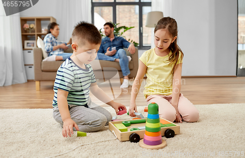 Image of brother and sister playing toy blocks at home