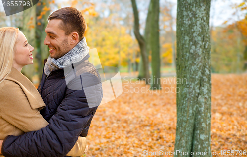 Image of smiling couple hugging in autumn park