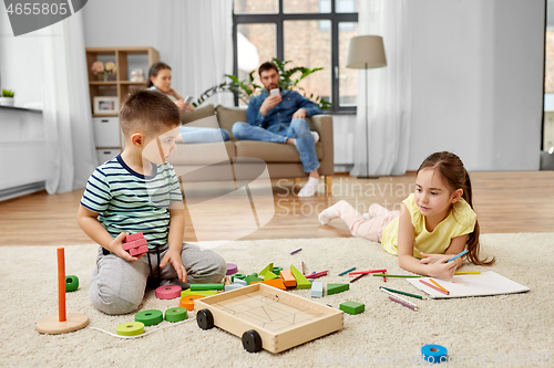 Image of brother and sister playing and drawing at home