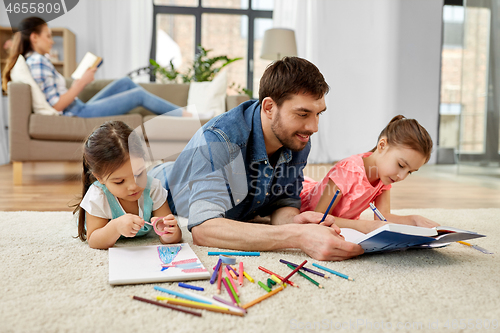 Image of father spending time with little daughters at home