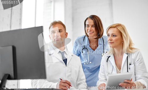 Image of group of doctors with computer at hospital