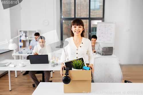 Image of happy businesswoman with personal stuff at office