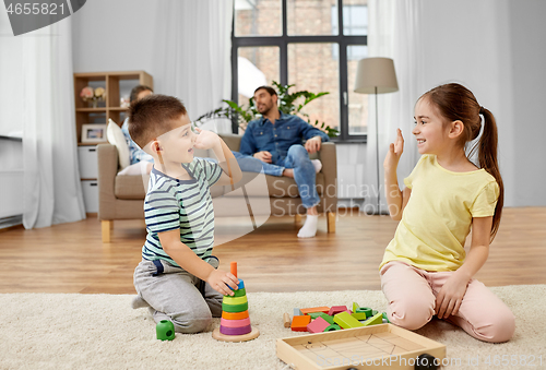 Image of brother and sister playing toy blocks at home