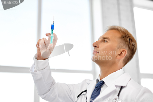 Image of smiling doctor with syringe at hospital