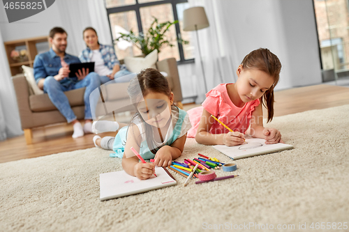 Image of happy sisters drawing in sketchbooks at home