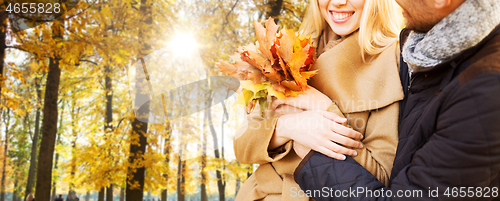 Image of close up of smiling couple hugging in autumn park