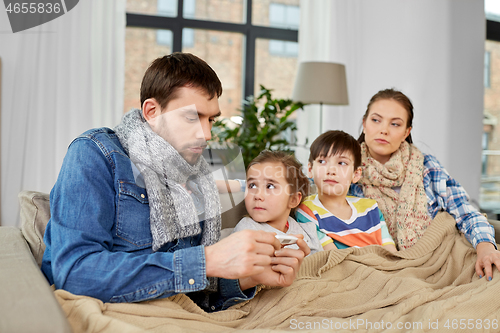 Image of family with ill children having fever at home