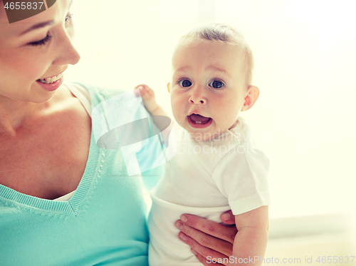 Image of happy young mother with little baby at home