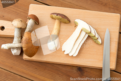 Image of edible mushrooms, kitchen knife and cutting board