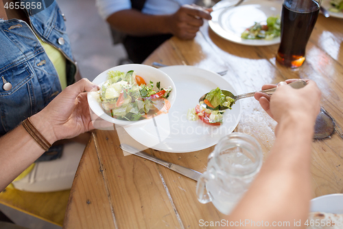 Image of international friends eating at restaurant