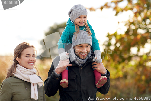 Image of happy family walking in autumn