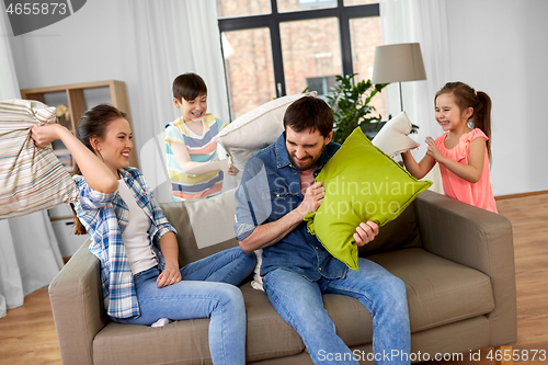 Image of happy family having pillow fight at home