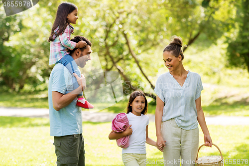 Image of happy family with picnic basket in summer park